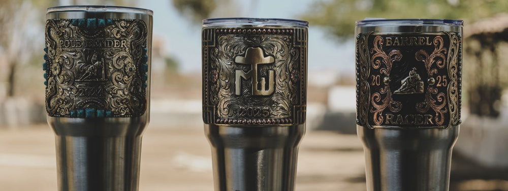 Three stainless tumblers wrapped in hand-engraved silver rodeo trophy plates